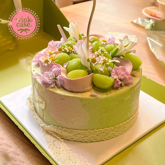 生日蛋糕,奶油蛋糕,绿色调,饰以混合绿色葡萄和浪漫的紫色鲜花。