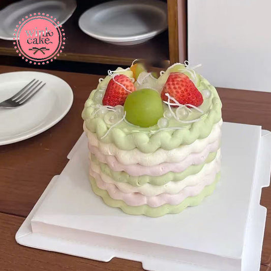 色彩缤纷的多层蛋糕，上面点缀着新鲜草莓和葡萄。