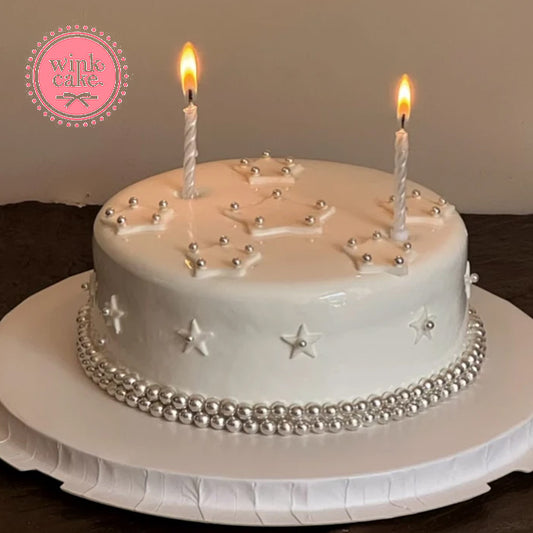 Simple Korean-style birthday cake decorated with stars and pearls.