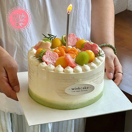 Birthday cake with full toppings and a variety of fresh fruits.