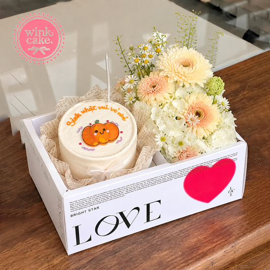 Gift box with cake and fresh flowers in a vibrant yellow tone.